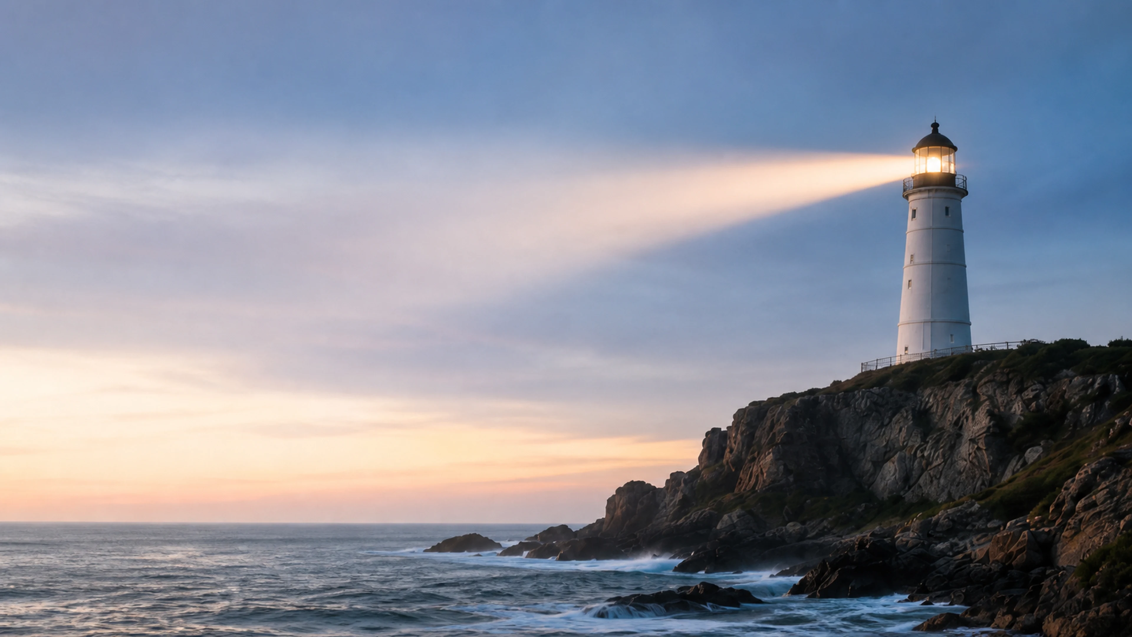 A lighthouse shining across the sea at dusk